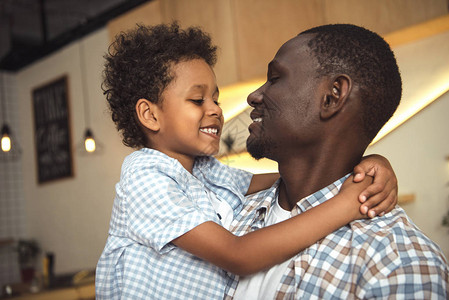 快乐的非洲美国父亲和孩子拥图片