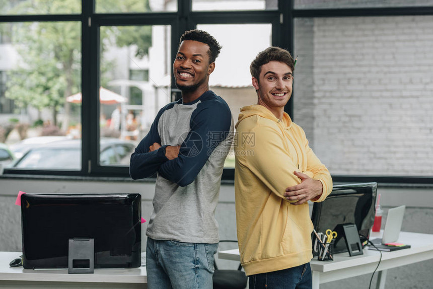 两个快乐的多文化程序员背靠站着图片