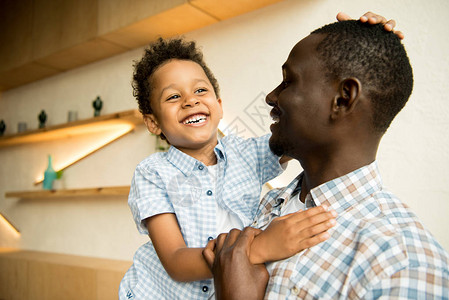 快乐的非洲美国父亲和可爱的小儿子拥图片