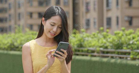 女人在户外玩手机图片