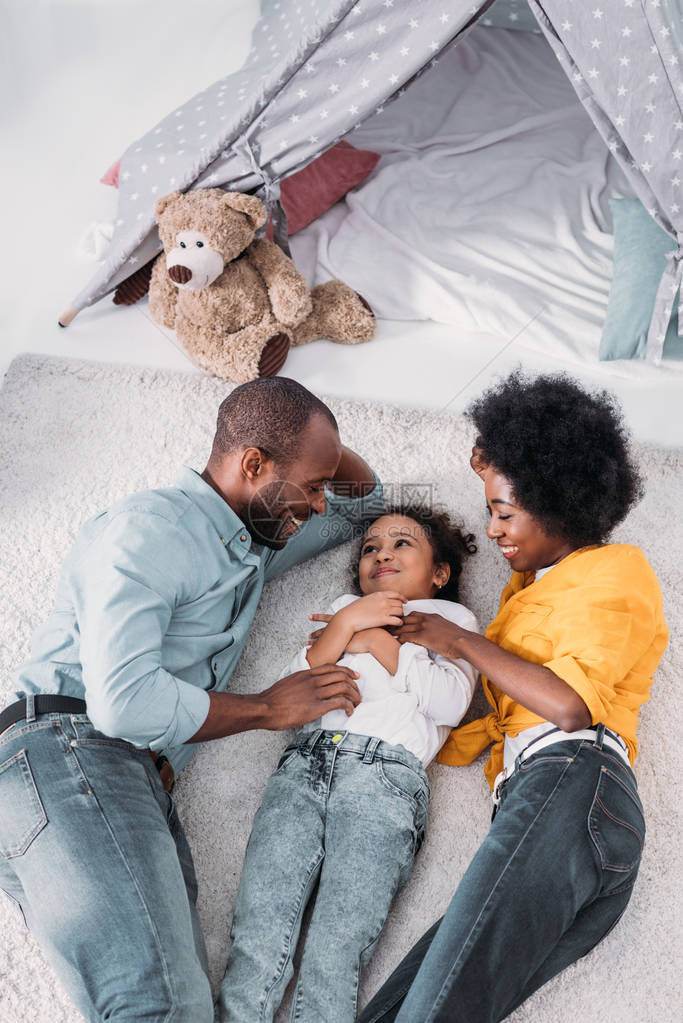 AfricanAmerican父母和女儿在家里的地板上玩乐图片