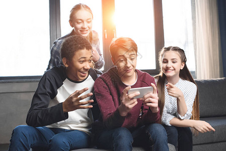 快乐的多元文化青少年用智能手机进行视频通话图片