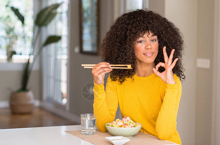 非裔美国妇女在家里吃亚洲大米图片