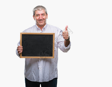 英俊的高级教师拿着黑板在与世隔绝的背景下高兴地笑着做好手势图片