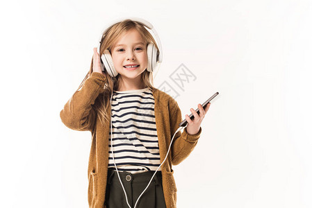 可爱的小孩用耳机和智能手机监听音乐在图片
