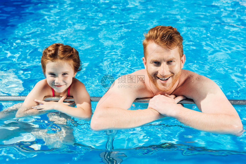 快乐的父亲和女儿在游泳池里共度时光在图片