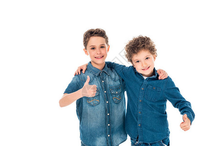 两个孩子穿着戴尼姆衬衫拥抱和显示拇指图片