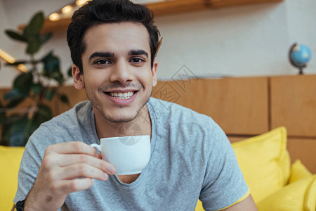男人带着一杯咖啡笑着看镜背景图片