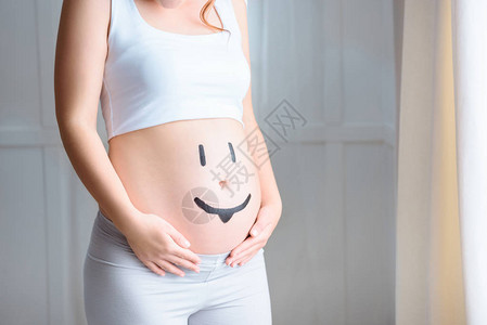 在家里肚子上印有微笑符号的孕妇被切图片