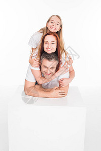年轻微笑的家庭拥抱和看着摄影机图片
