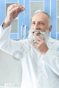 白大衣中带着化学实验室试剂的管子的笑着微笑的高级图片