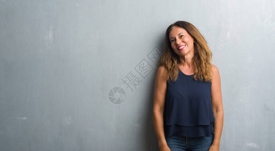 站在灰墙上站着的中年西班牙女人图片