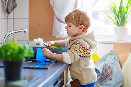 有趣的金发小男孩在国内厨房洗碗快乐的孩子在帮助做家务时很开心在室内图片
