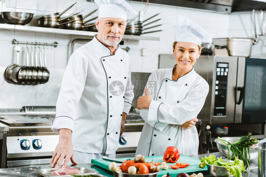 穿制服的女厨师和男厨师在餐厅厨房做饭图片