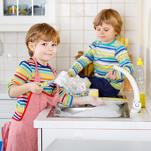 两个有趣的小男孩朋友在家庭厨房洗碗孩子们在帮助做家务时很开心在室内图片