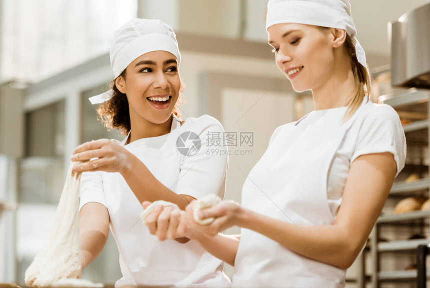 快乐的女面包师在烘烤生图片