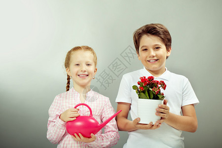 可爱的儿童与室内植物和喷壶的肖像图片