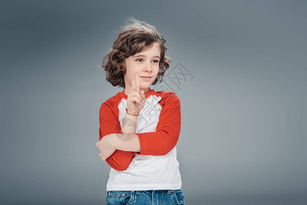 沉思的孩子用灰色的交叉双臂做手势图片