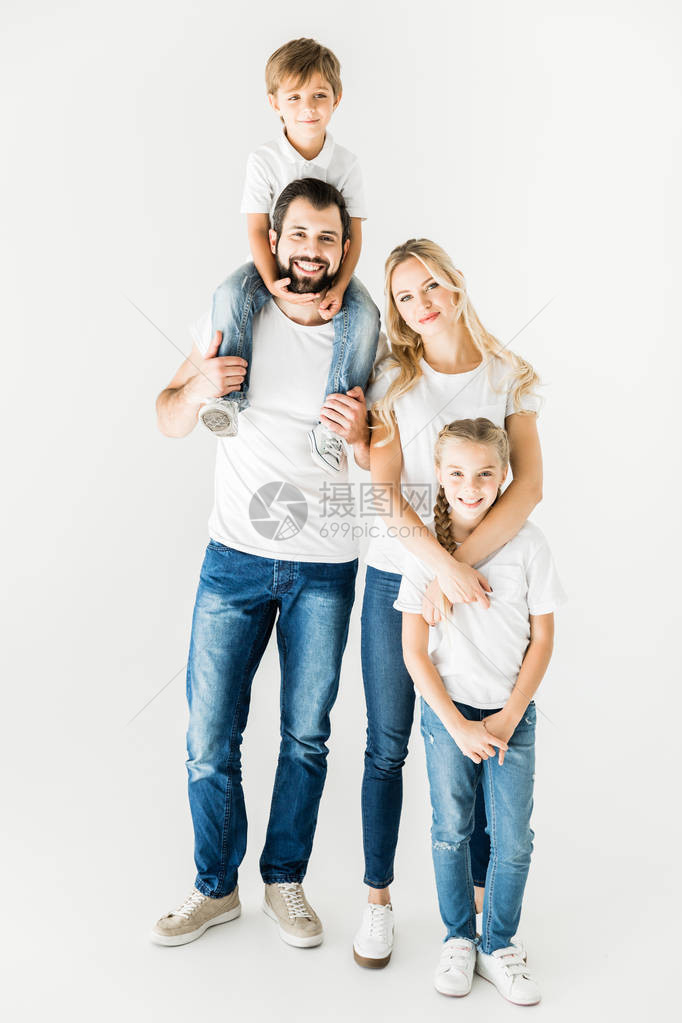 穿着白色T恤衫的年轻幸福家庭微笑着在镜头中被图片