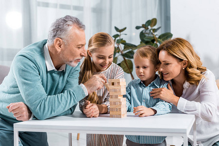 快乐的祖父母和孙辈在家一起玩木塔游戏图片