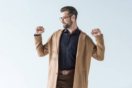 兴奋的男人在秋天的棕色外套中打手势和摆姿势图片