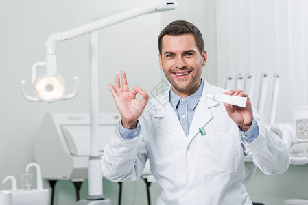 牙医在牙科诊所内持有牙膏和图片