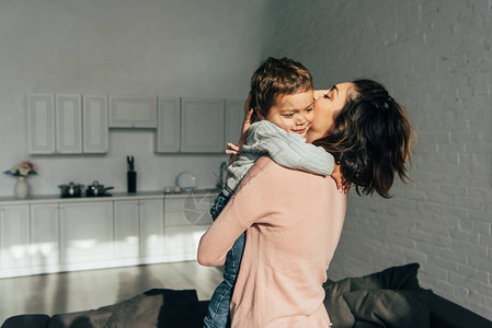 女人在家里拥抱和着可爱的小儿子图片