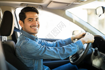 有吸引力的西班牙裔年轻男子坐在汽车驾驶座上进行眼图片