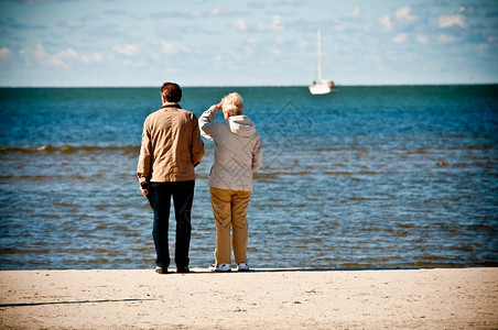 老夫妇在海边看船海背景图片