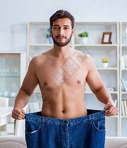 减肥概念中穿超大裤子的男人图片