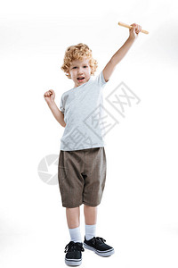 小男孩表现出成功的姿态并拿着木棍孤立在背景图片
