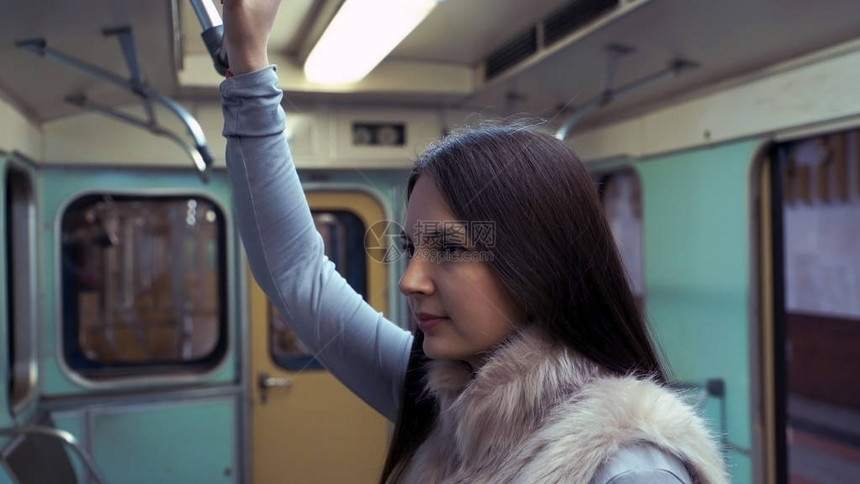 年轻女孩乘坐地铁并握住扶手图片