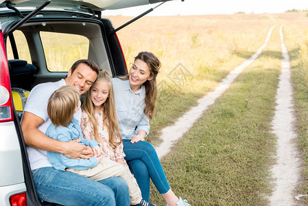 年轻美丽的家庭在出车旅行时一起田野度过时间图片