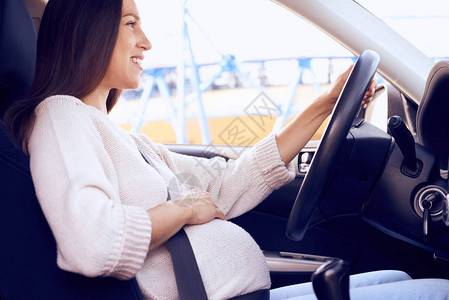 笑着微笑的孕妇驾驶汽图片