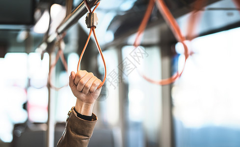 手握电车火车公共汽车或地铁的把手站在公共交通工具上的乘客通勤的人图片