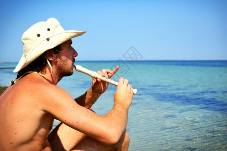 年轻人在海边吹长笛图片