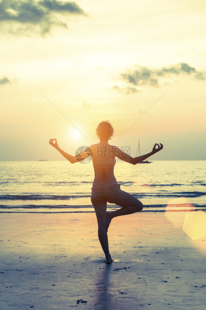 在海边的瑜伽剪影在令人惊叹的大海和日落背景下的冥想女孩女人图片