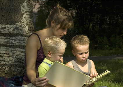 家人坐在树边看书图片