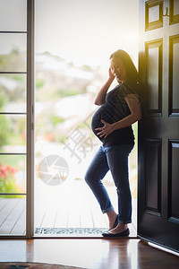 幸福的孕妇站在门卫图片