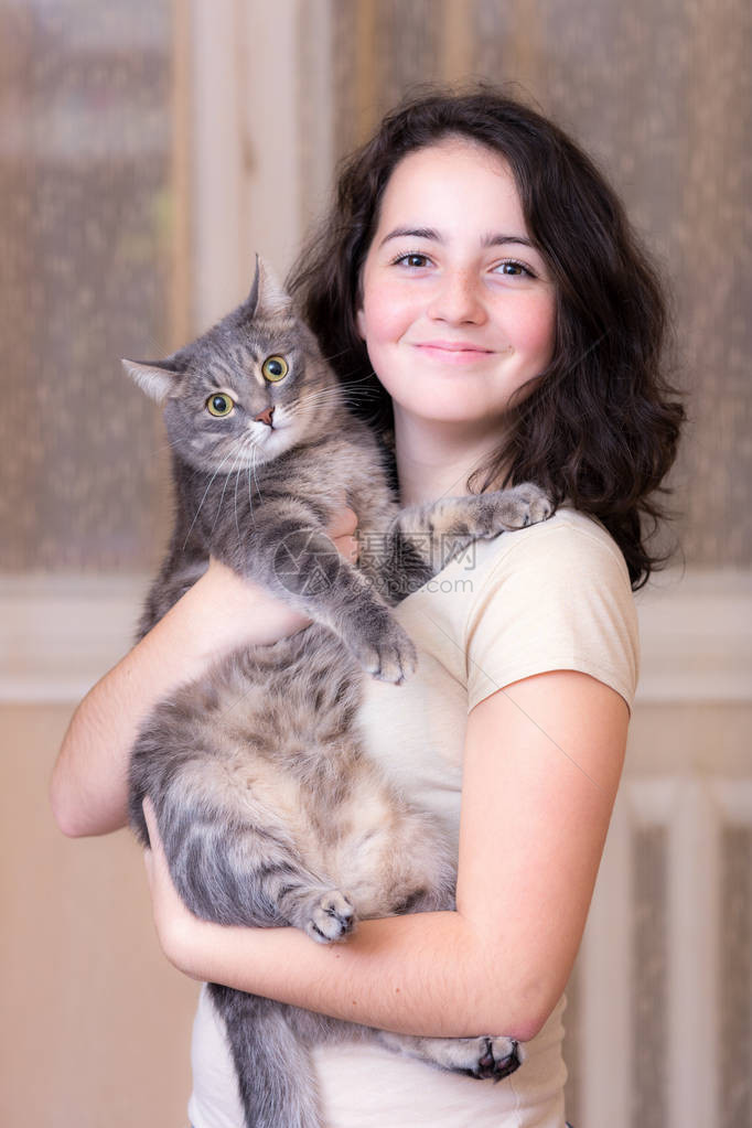 一个十几岁的女孩和一只宠物猫的肖像图片
