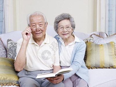 亚洲老夫妇在家一起看书图片