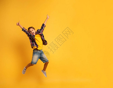 快乐的孩子跳过黄色背景图片