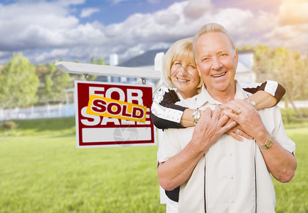 在出售的房地产标志和房屋前拥抱着快乐背景图片