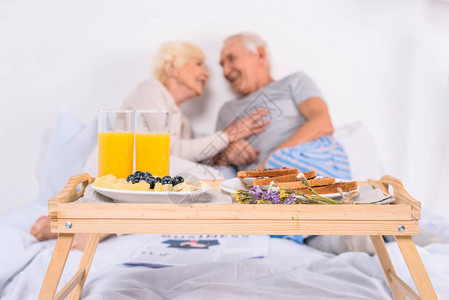 以早餐和在家床上的幸福老年夫妇图片