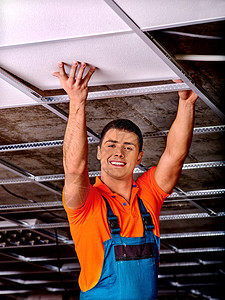 橙色建筑工人制服安装吊顶的人图片