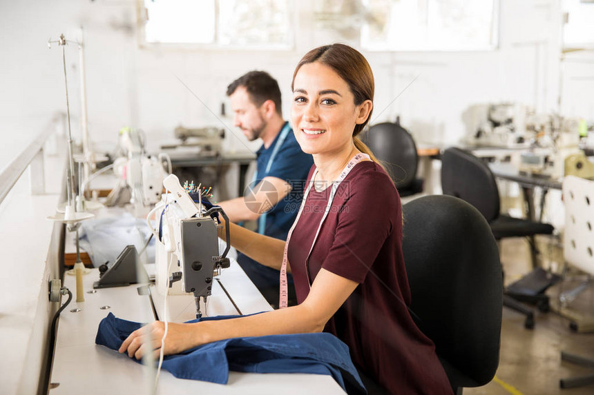 在纺织厂里用缝纫机微笑着的美图片