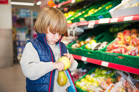 小男孩在超市挑选蔬菜图片