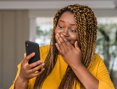 使用智能手机的非洲美妇女用手震动嘴部图片