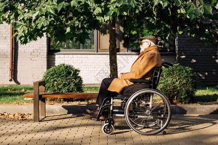 坐在街上轮椅上的老年残图片