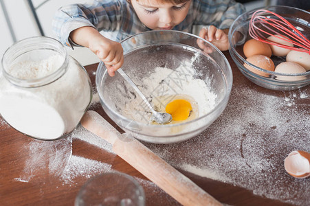 小孩用面粉和鸡蛋准备图片